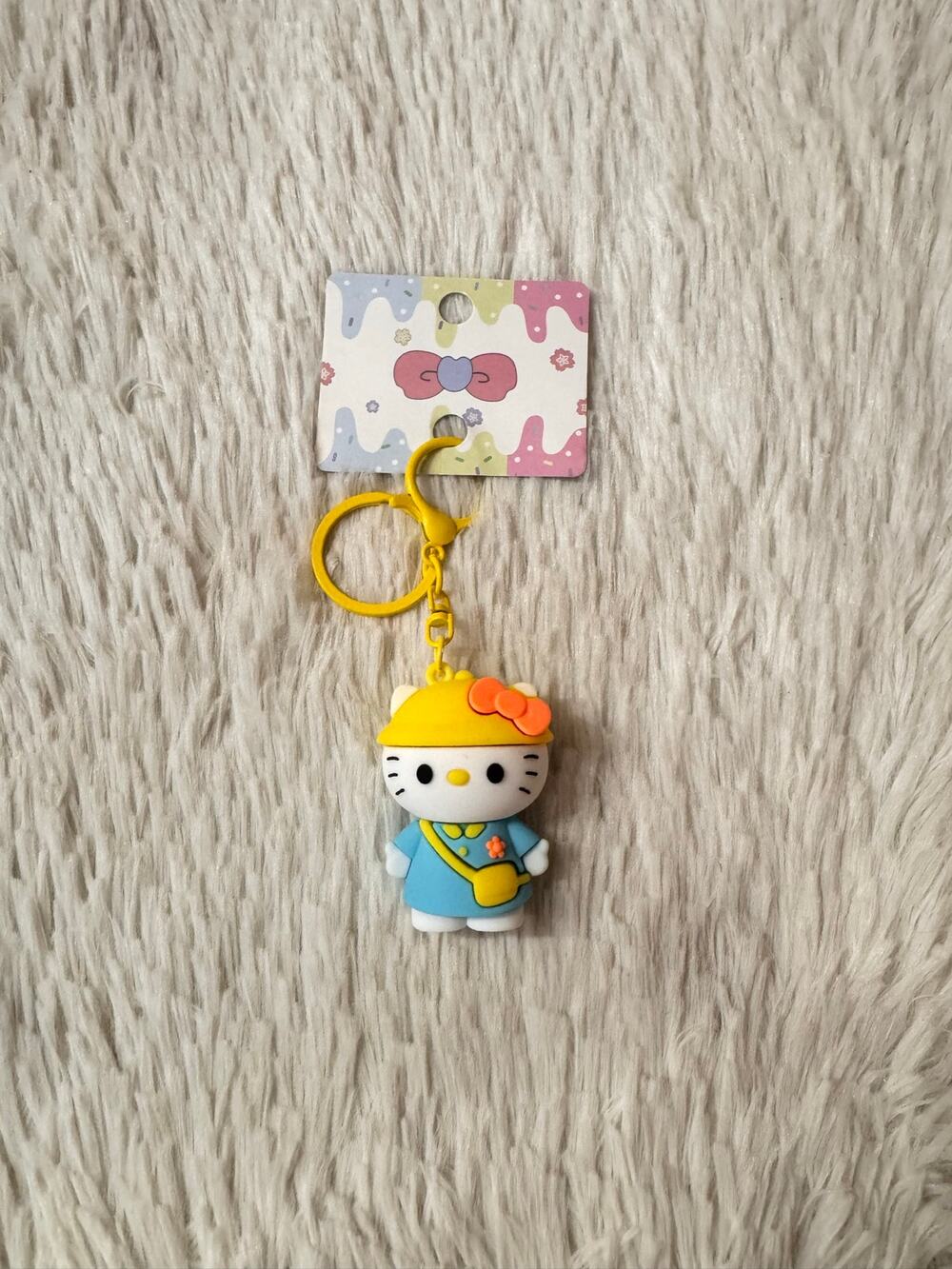 Hello Kitty keychain with yellow hat and blue dress with orange bow